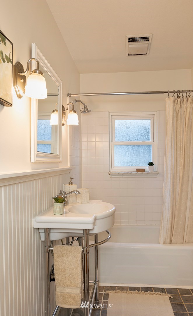 708 North 63rd Street Seattle, WA 98103 - Photo 17 of 24 a bathroom with a sink and a mirror