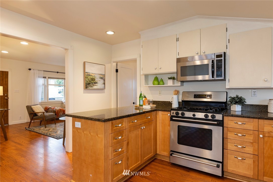708 North 63rd Street Seattle, WA 98103 - Photo 7 of 24 a kitchen with stainless steel appliances granite countertop a stove a sink and a microwave