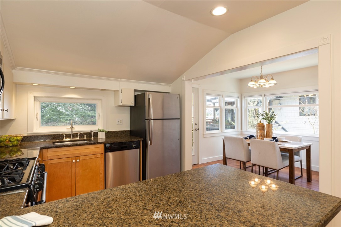 708 North 63rd Street Seattle, WA 98103 - Photo 10 of 24 a living room with stainless steel appliances kitchen island granite countertop a refrigerator and a stove top oven