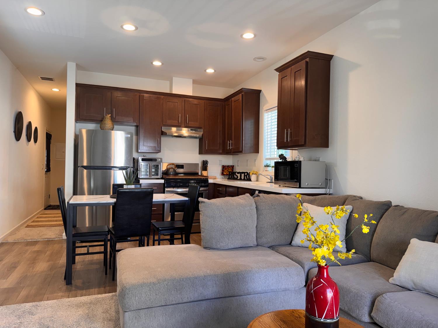 360 East Grant Line Road, Unit 16 Tracy, CA 95376 - Photo 3 of 36 Open-concept kitchen and living area featuring wood-finish flooring, recessed lighting, and a kitchen with dark wood cabinetry