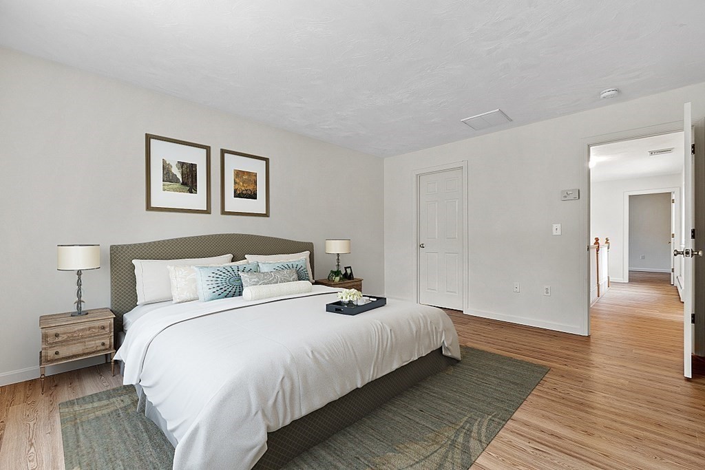 11 Longley Road, Unit I1 Shirley, MA 01464 - Photo 12 of 28 a bedroom with a bed and a painting on the wall