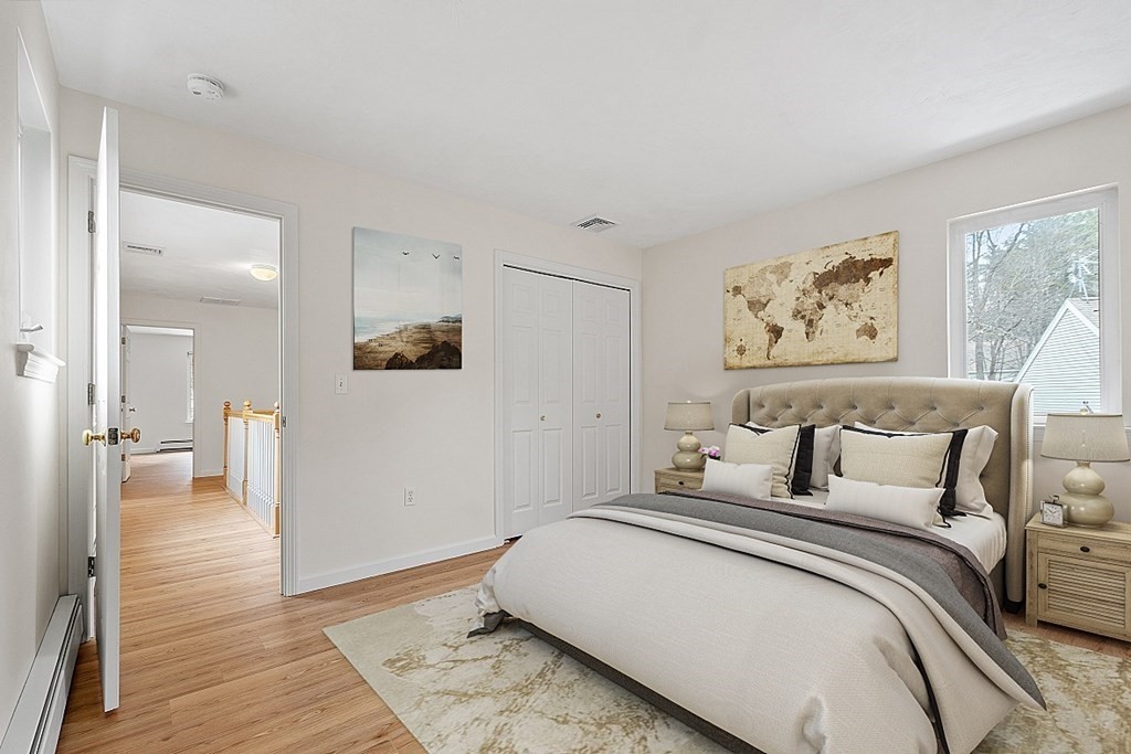 11 Longley Road, Unit I1 Shirley, MA 01464 - Photo 15 of 28 a bedroom with a large bed and painting on the wall