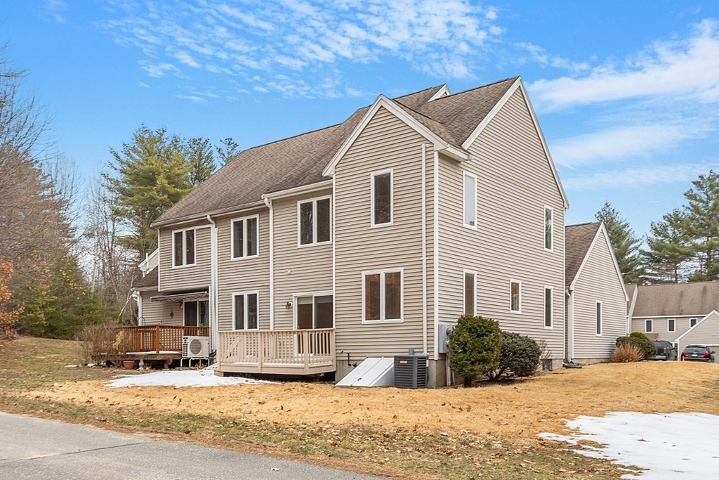 11 Longley Road, Unit I1 Shirley, MA 01464 - Photo 3 of 28 a view of a white house with a yard covered in snow