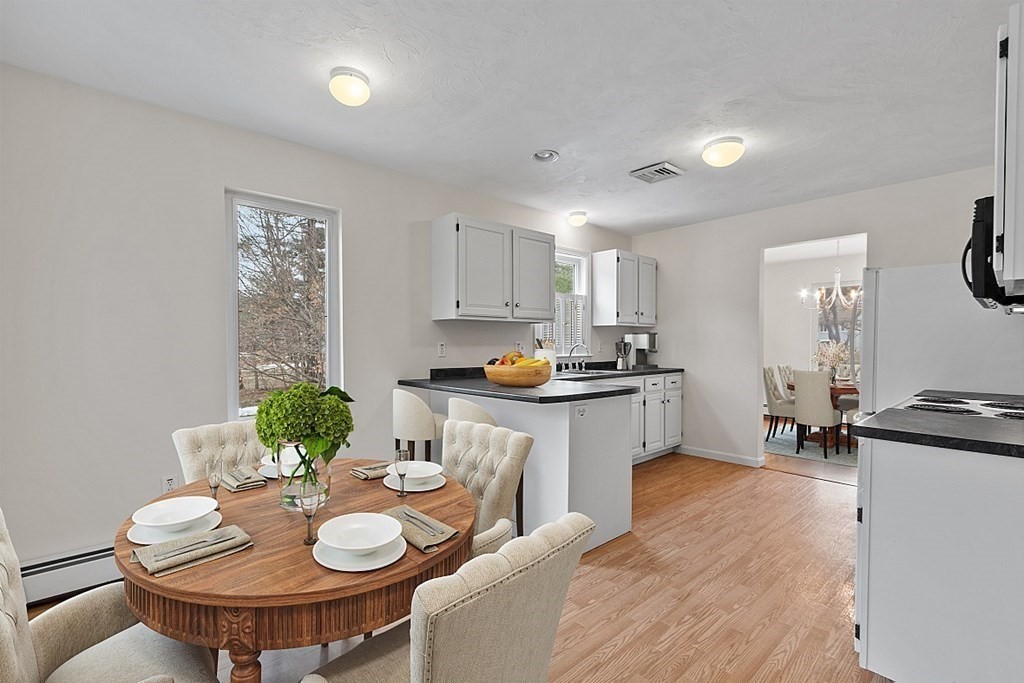 11 Longley Road, Unit I1 Shirley, MA 01464 - Photo 5 of 28 a kitchen with granite countertop a white cabinets and chairs