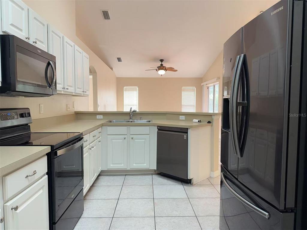 9717 Crenshaw Circle Clermont, FL 34711 - Photo 5 of 11 a kitchen with a sink stainless steel appliances and cabinets