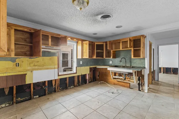 a view of a kitchen with stainless steel appliances granite countertop a stove and a sink