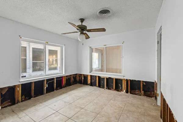 a large white bedroom with a large bed and a window