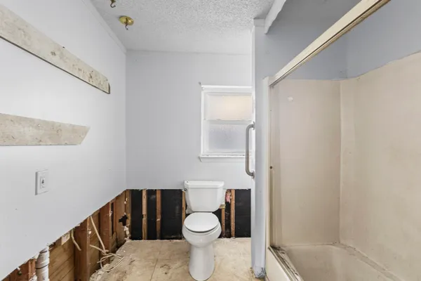 a bathroom with a granite countertop toilet a sink and a mirror