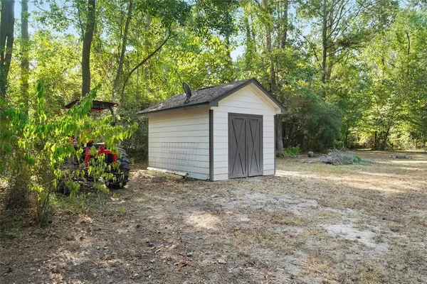 a view of a house with a small yard and trees