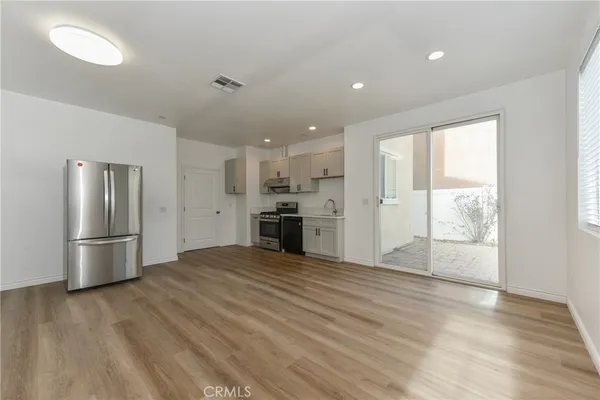 a view of a kitchen with a stove refrigerator and wooden floor