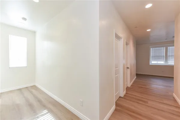 a view of a hallway with wooden floor and closet