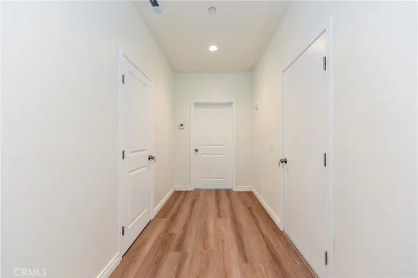 a view of a room with wooden floor and a hallway