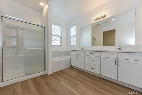 a spacious bathroom with a double vanity sink a mirror and a shower