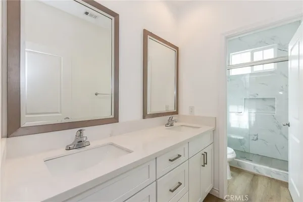 a bathroom with a sink a toilet and a large mirror