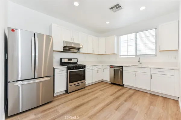 a kitchen with a refrigerator stove and wooden cabinets