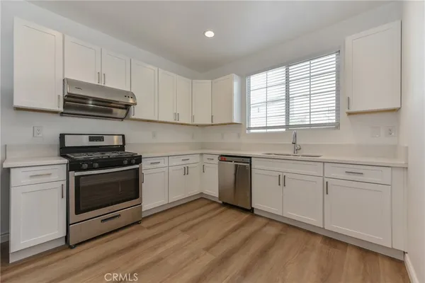 a kitchen with granite countertop white cabinets and appliances