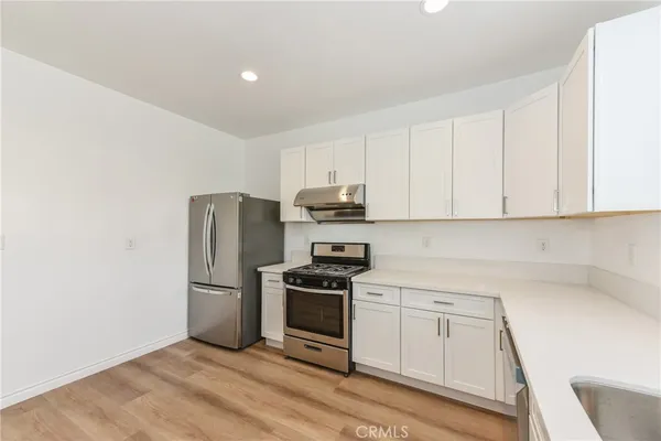 a kitchen with a refrigerator stove and white cabinets