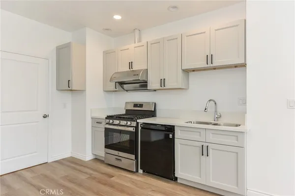 a kitchen with stainless steel appliances granite countertop a sink stove and cabinets