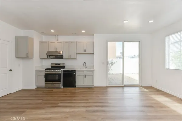 a kitchen with stainless steel appliances kitchen island granite countertop a stove a sink and a refrigerator