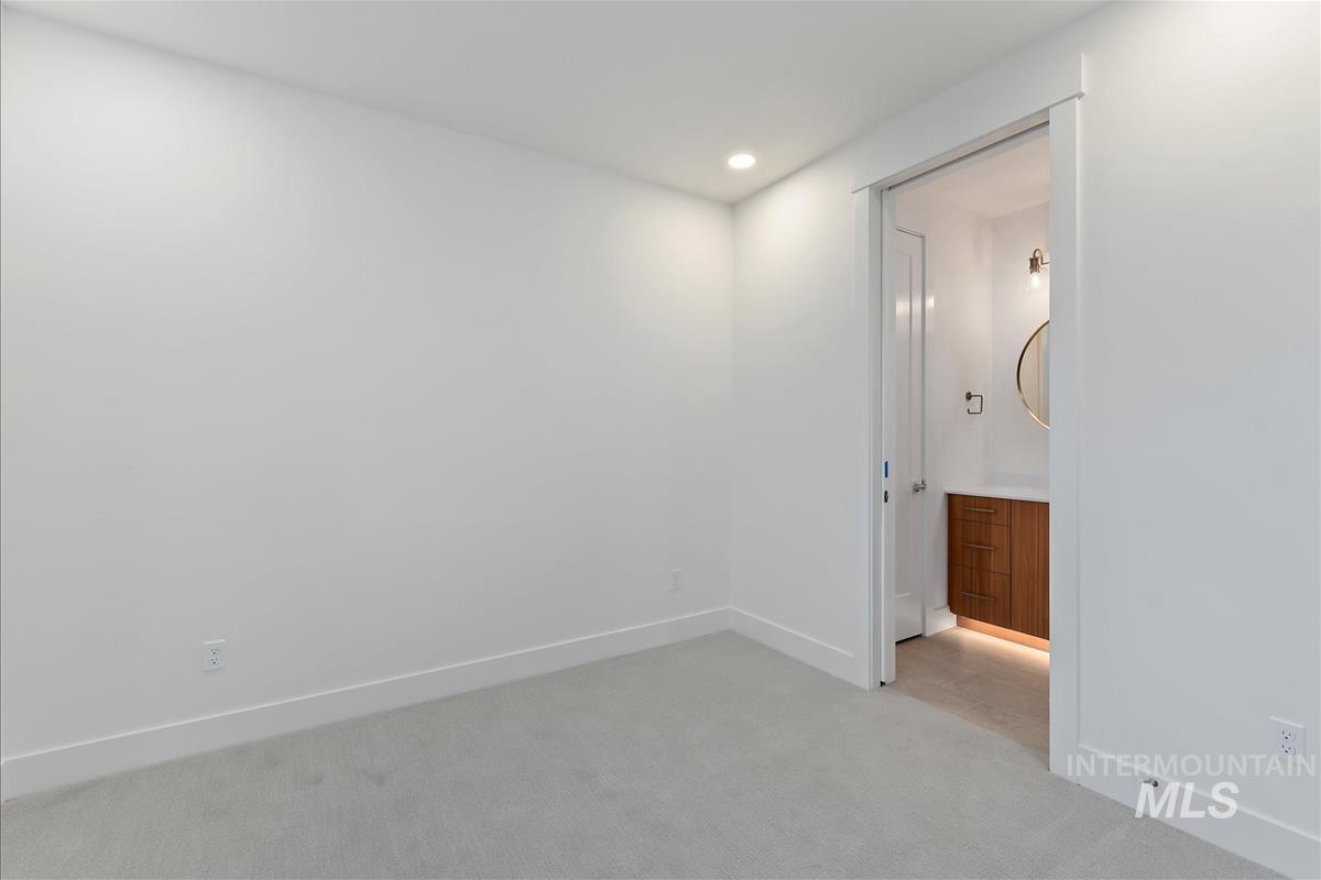 3213 West Moore Street Boise, ID 83702 - Photo 26 of 32 Room featuring light gray carpeting, recessed ceiling lighting, and a pocket door opening to a bathroom