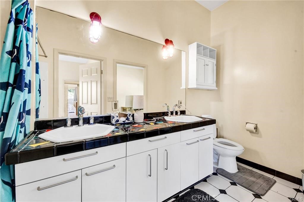 5084 Campo Road Los Angeles, CA 91364 - Photo 18 of 29 a bathroom with a double vanity sink toilet and a mirror