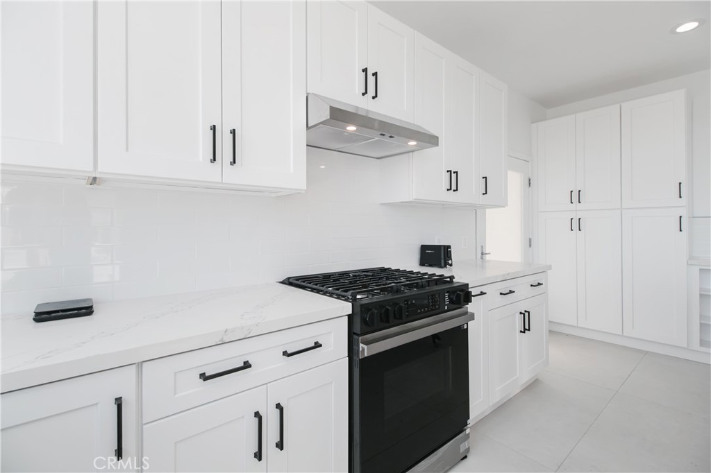 5084 Campo Road Los Angeles, CA 91364 - Photo 28 of 29 a kitchen with white cabinets and stove