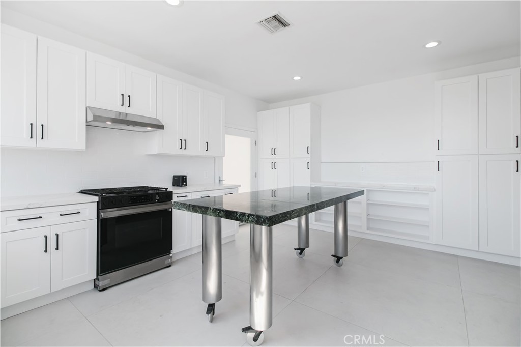 5084 Campo Road Los Angeles, CA 91364 - Photo 3 of 29 a kitchen with stainless steel appliances a stove a chimney a sink and cabinets