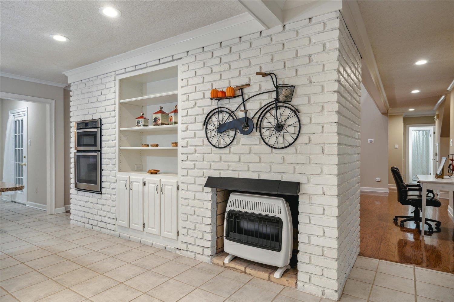 8450 Thor Road Memphis, TN 38018 - Photo 13 of 32 Tiled living room featuring heating unit, built in features, a textured ceiling, and ornamental molding