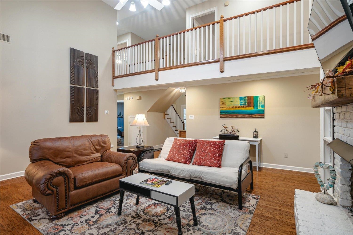 8450 Thor Road Memphis, TN 38018 - Photo 7 of 32 Living room featuring a fireplace, ceiling fan, a towering ceiling, and dark wood-type flooring