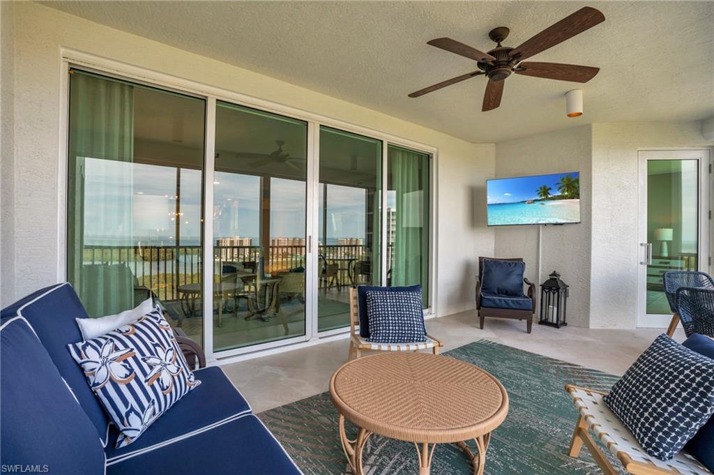 265 Indies Way, Unit 1402 Naples, FL 34110 - Photo 40 of 45 a living room with furniture a rug potted plant and a large window