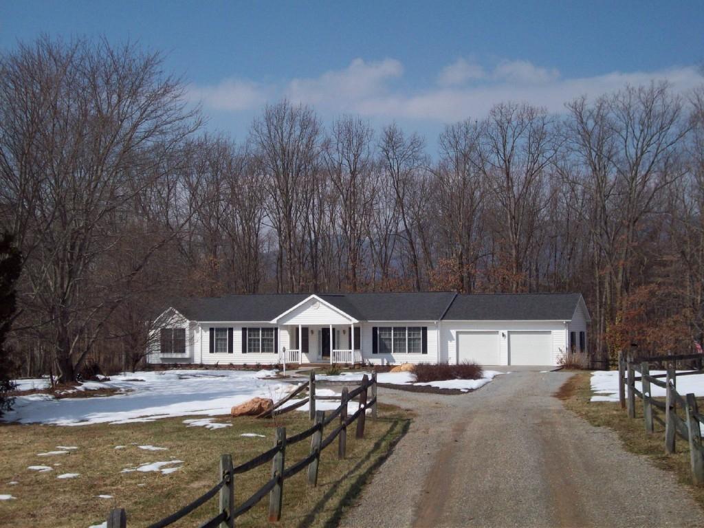 3379 Retreat Road Boones Mill, VA 24065 - Photo 1 of 6 a front view of a house with yard fire pit and trees around