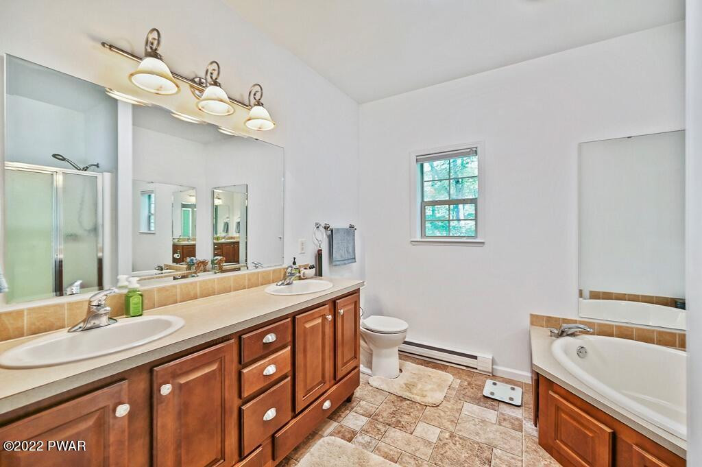 131 Anderson Road Lake Ariel, PA 18436 - Photo 17 of 47 a spacious bathroom with a double vanity sink a mirror a bathtub and a toilet