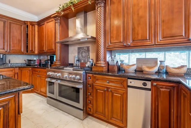 a kitchen with stainless steel appliances granite countertop a stove a sink and cabinets