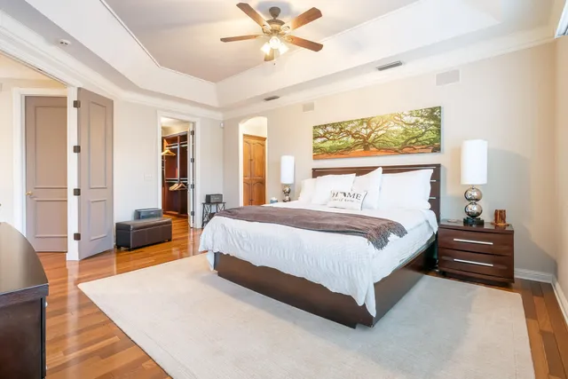 a spacious bedroom with a bed a dresser and a large window