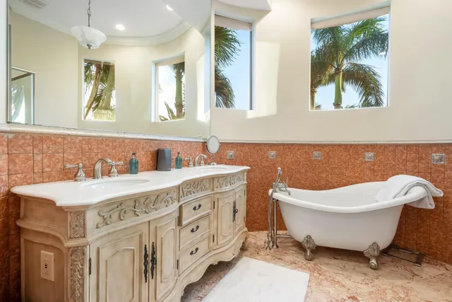 a spacious bathroom with a double vanity sink mirror and bathtub