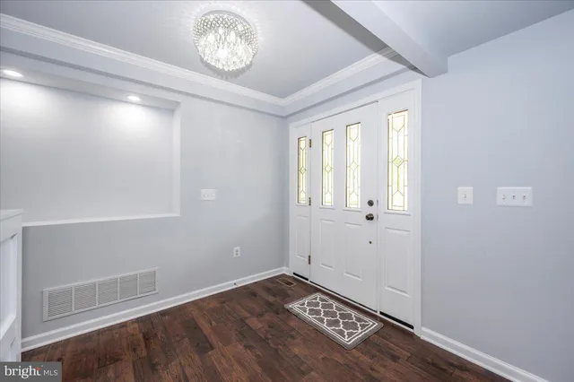 a kitchen with stainless steel appliances granite countertop a refrigerator a sink dishwasher a stove and white countertops with wooden floor