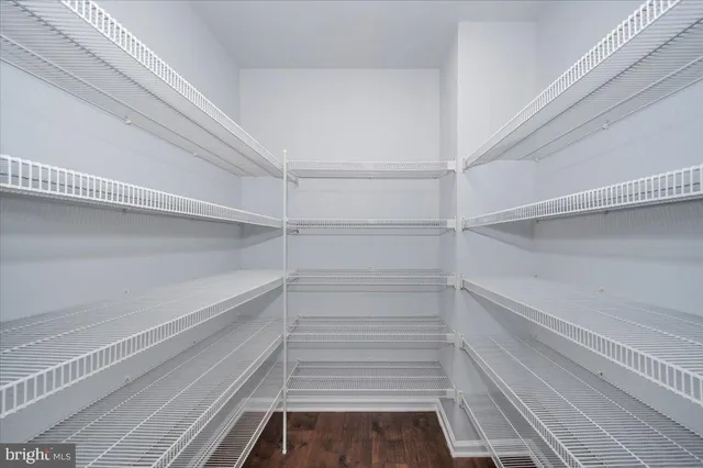 an empty room with an entryway and chandelier fan