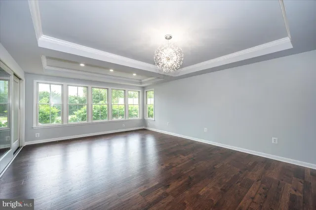 a view of an empty room with a chandelier fan