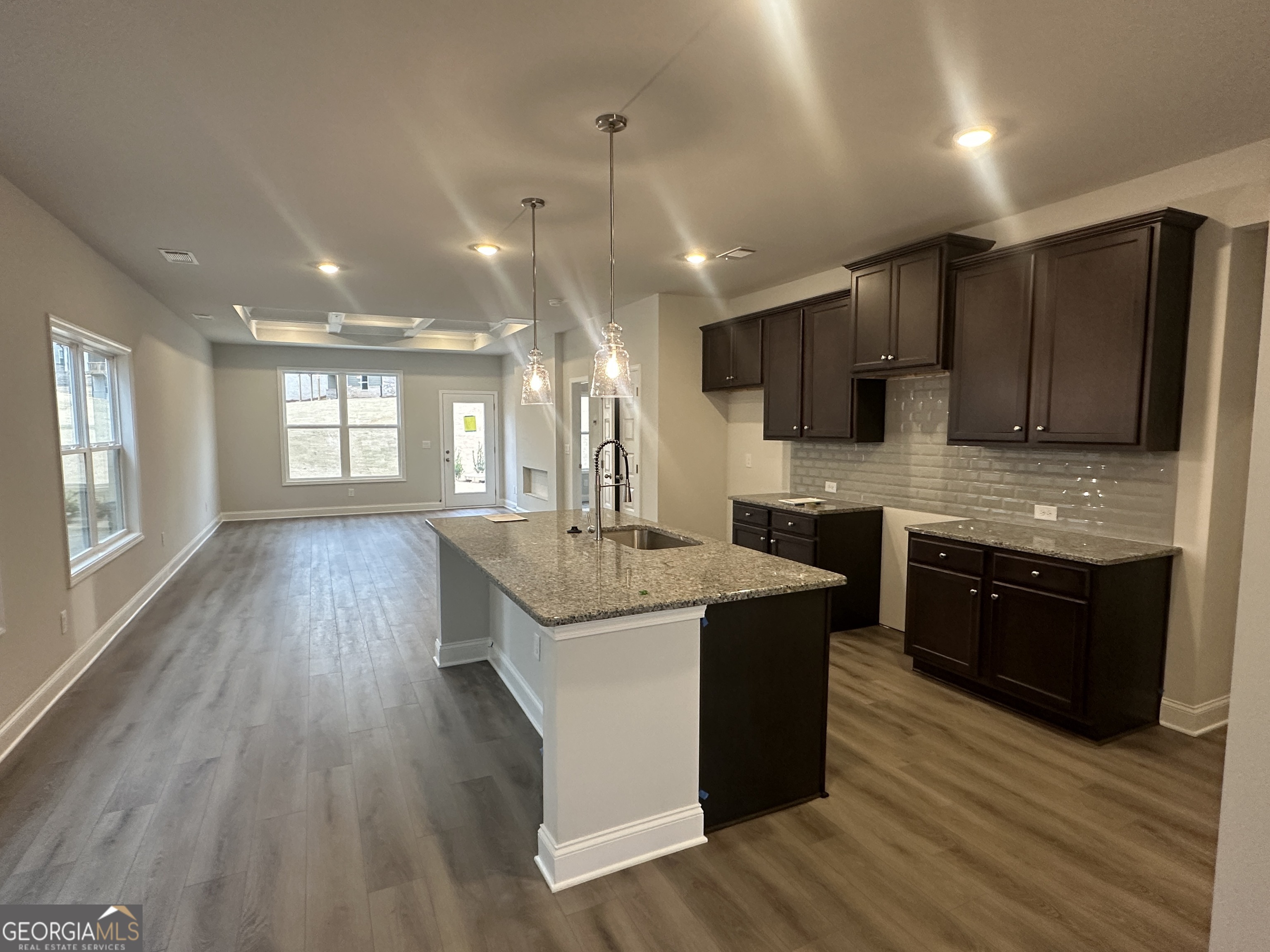17 Butternut Way, Unit 118B Auburn, GA 30011 - Photo 2 of 53 a large kitchen with stainless steel appliances kitchen island granite countertop a stove a refrigerator a sink a microwave and wooden floors