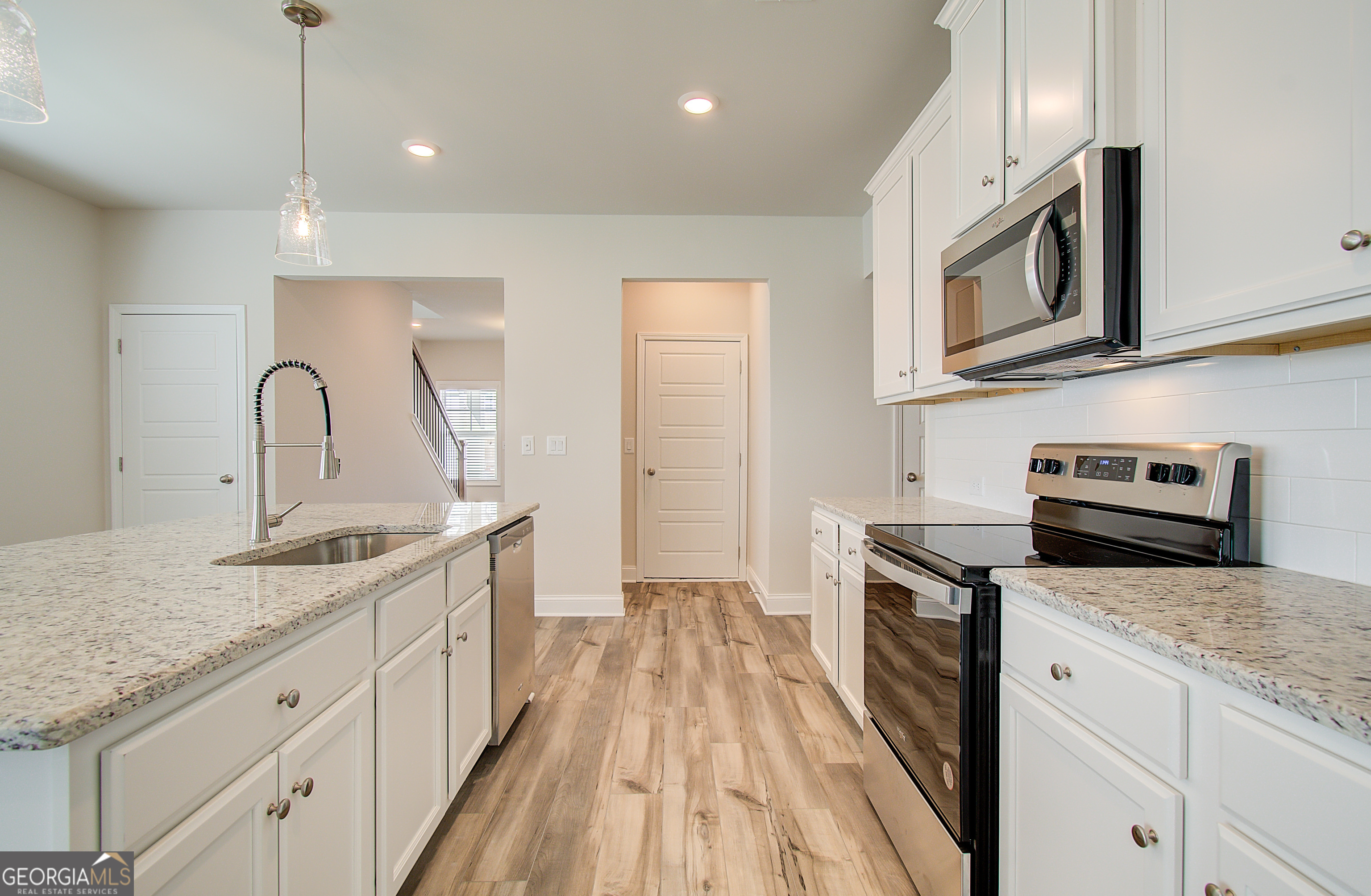 17 Butternut Way, Unit 118B Auburn, GA 30011 - Photo 33 of 53 a kitchen with stainless steel appliances granite countertop a sink a stove and a wooden floors