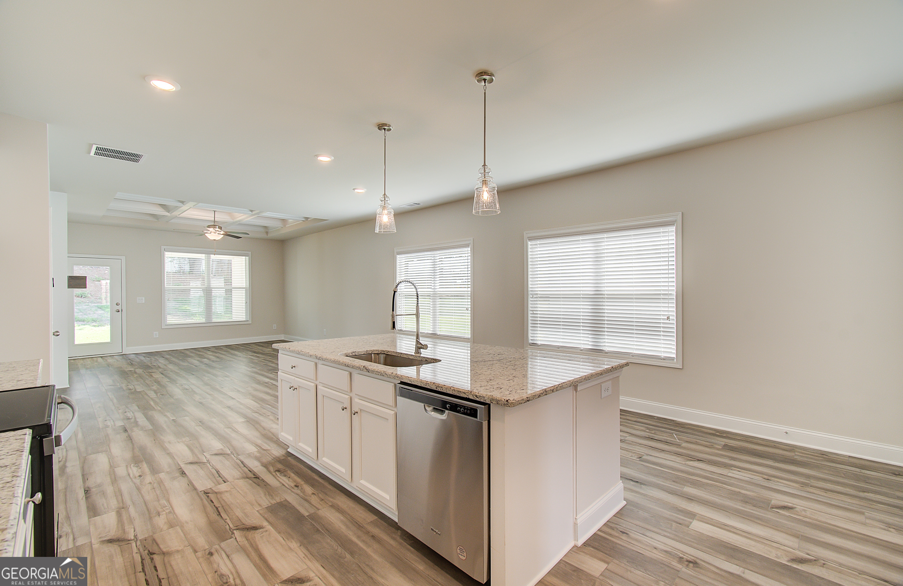 17 Butternut Way, Unit 118B Auburn, GA 30011 - Photo 35 of 53 a kitchen with stainless steel appliances granite countertop a sink a window and wooden floors