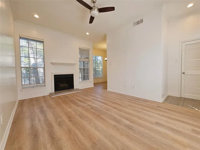 an empty room with windows and fireplace