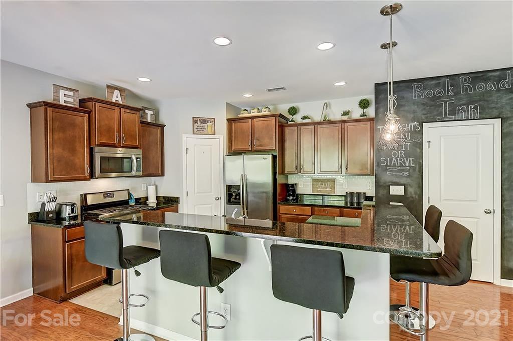 923 Rook Road Charlotte, NC 28216 - Photo 13 of 36 a kitchen with stainless steel appliances granite countertop a stove refrigerator sink and chair