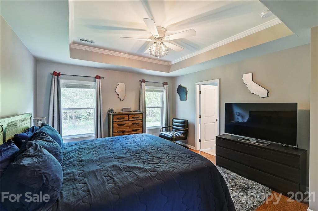 923 Rook Road Charlotte, NC 28216 - Photo 22 of 36 a bedroom with a bed and a flat screen tv