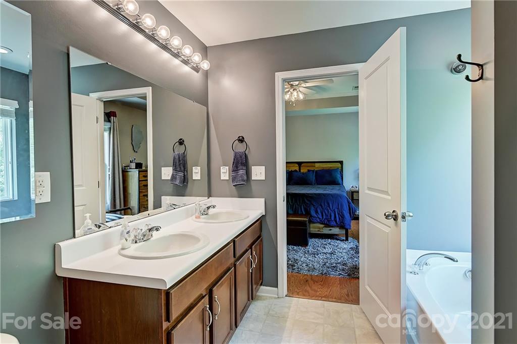 923 Rook Road Charlotte, NC 28216 - Photo 23 of 36 a en suite bathroom with a sink a mirror and a shower