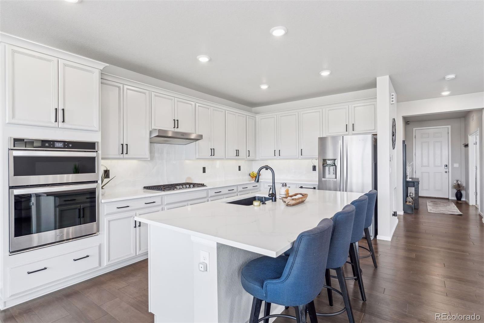 23913 East Minnow Circle Aurora, CO 80016 - Photo 12 of 49 a kitchen with stainless steel appliances a stove a white table and chairs