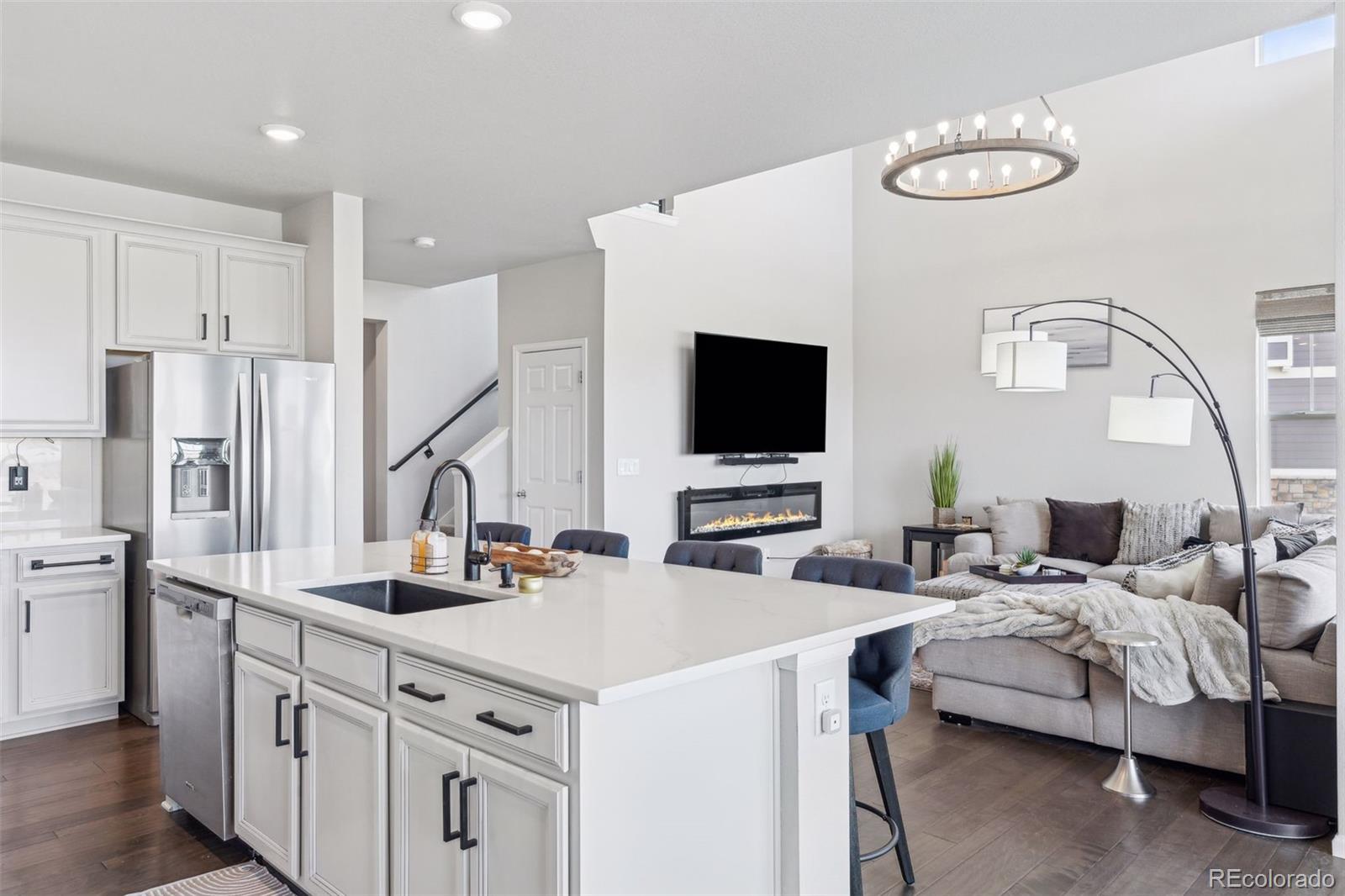 23913 East Minnow Circle Aurora, CO 80016 - Photo 14 of 49 a kitchen with stainless steel appliances a stove a sink and white cabinets