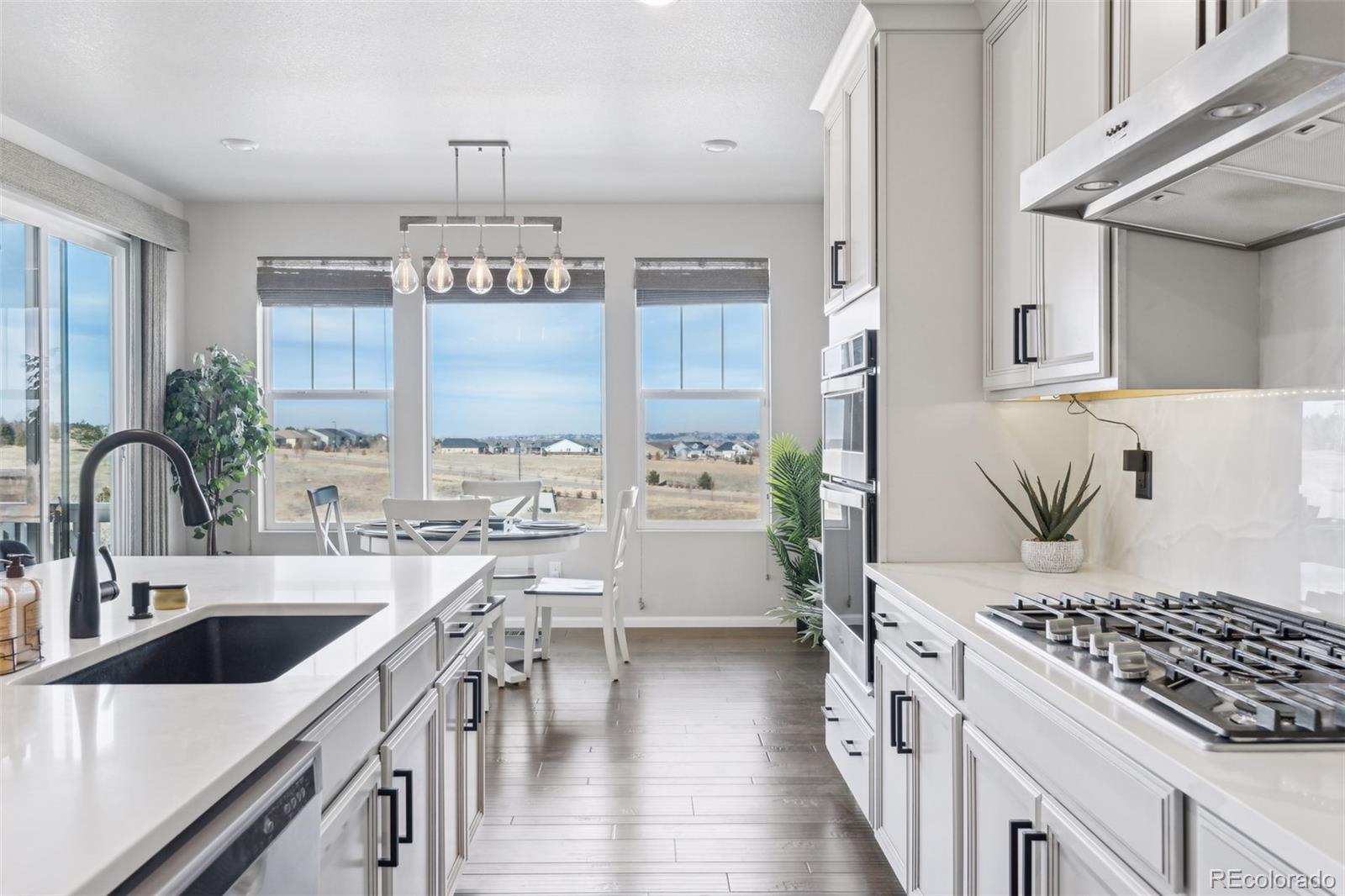 23913 East Minnow Circle Aurora, CO 80016 - Photo 15 of 49 a kitchen with stove and white cabinets