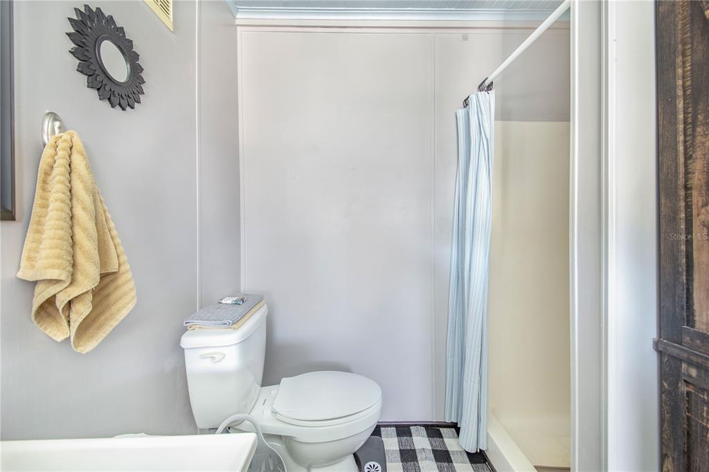 475 Pine Loop Frostproof, FL 33843 - Photo 18 of 40 a bathroom with a toilet and a shower curtain