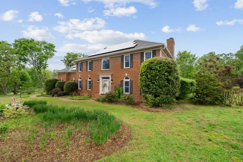 a bathroom with a granite countertop sink mirror vanity and toilet